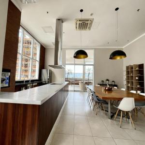 a kitchen with a wooden counter and a dining table at Metropolitan Barcelona próximo Flamboyant e Autódromo in Goiânia