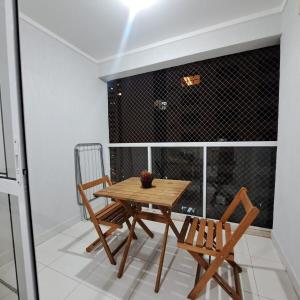 un tavolo di legno e due sedie su un balcone di Metropolitan Barcelona próximo ao Flamboyant e Autódromo Ar condicionado no quarto e na sala Piscina e jacuzzi no terraço academia completa restaurantes no térreo vaga privativa a Goiânia
