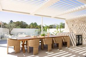 an outdoor dining room with a wooden table and chairs at Private Beachside Escape – 5-Star Luxury for Families Friends in South West Rocks