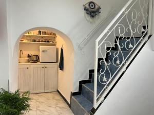 pasillo con escalera y cocina con nevera. en Maison traditionnelle totalement privée au médina, en Chefchaouen