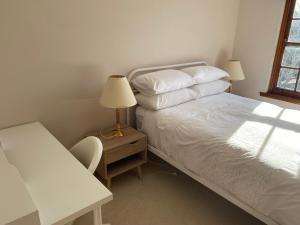 a bedroom with a bed and a desk with a lamp at Hillside Retreat with Pool in Flagstaff Hill +9 photos