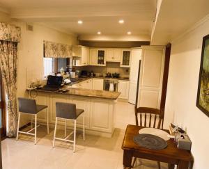 a kitchen with white cabinets and a table and chairs at Hillside Retreat with Pool in Flagstaff Hill