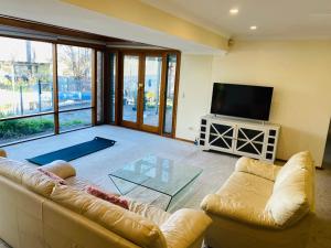 a living room with a couch and a television at Hillside Retreat with Pool in Flagstaff Hill
