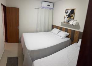 two beds in a small room with a window at Verão João Pessoa-apto inteiro-2 quartos in Cabedelo +8 photos