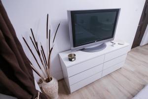 einen TV auf einer weißen Kommode in einem Zimmer in der Unterkunft Cozy central studio in Craiova