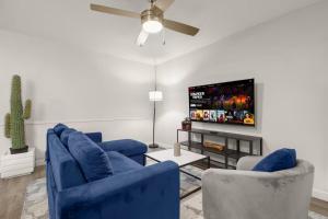 a living room with two blue chairs and a flat screen tv at ATX Casa Tranquila in Austin