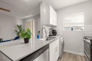 a white kitchen with a sink and a refrigerator at ATX Casa Tranquila in Austin