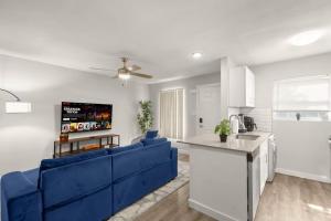 a living room with a blue couch and a kitchen at ATX Casa Tranquila in Austin