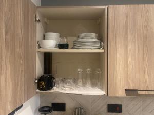 einem Schrank mit Gläsern, Tellern und Geschirr in der Unterkunft Belrose Place in Accra