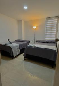 Ένα ή περισσότερα κρεβάτια σε δωμάτιο στο Stayplus Apartahotel San Gil