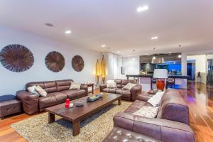 a living room with leather couches and a table at Starhaven Retreat in Portarlington