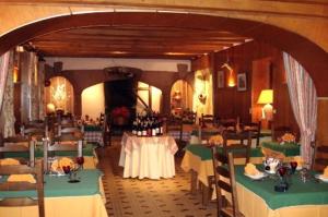 une salle à manger avec des tables et des chaises vertes et blanches dans l'établissement Auberge Aux Portes de Conques, à Saint-Cyprien-sur-Dourdou
