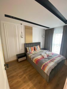 une chambre avec un grand lit avec un plancher en bois dans l'établissement Arad Apartamente Premium, à Arad