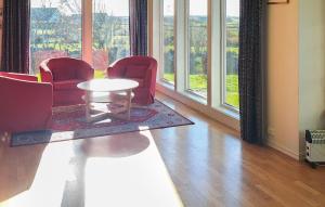 a room with chairs and a table in front of windows at 3 Bedroom Stunning Home In Vanse in Borhaug