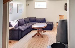 a living room with a blue couch and a table at 3 Bedroom Stunning Home In Vanse in Borhaug +7 photos