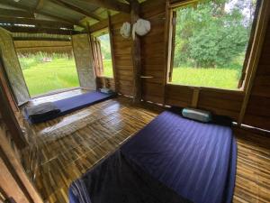 ein leeres Zimmer mit zwei Fenstern in einer Hütte in der Unterkunft Pang Ma - O rice terrace นาขั้นบันไดบ้านปางมะโอ in Ban Pha Mon + 25 Fotos