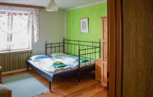 une chambre avec un lit dans une pièce aux murs verts dans l'établissement Stunning Home In Darlowo With Wifi, à Darłowo 11 autres photos