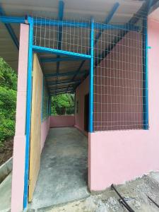 ein Eingang zu einem Gebäude mit rosa und blauen Wänden in der Unterkunft rumah pt sari  + 5 Fotos