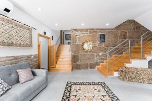ein Wohnzimmer mit einer Couch und einer Steinwand in der Unterkunft Sevenfarm in Mangualde