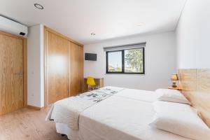 ein Schlafzimmer mit zwei weißen Betten und einem Fenster in der Unterkunft Sevenfarm in Mangualde