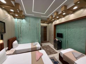 a room with two beds and a green wall at Cairo Püre, Plaza Hotel in Cairo