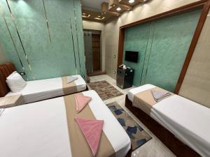 a room with two beds with pink napkins on them at Cairo Püre, Plaza Hotel in Cairo