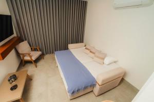 Apartment on the 21st floor, ocean and Sierra views في Simón Bolivar: غرفة نوم صغيرة بها سرير وكرسي +28 صورة