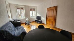 un salon avec une table et un canapé dans l'établissement St Dié Central, à Saint-Dié-des-Vosges