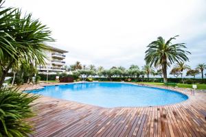 una gran piscina en un complejo con palmeras en GOLF ST JORDI 2 Planet Costa Dorada, en Cambrils