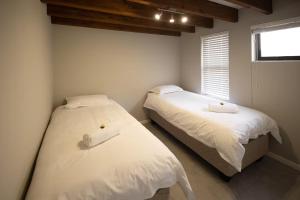 twee bedden in een kleine slaapkamer met een raam bij Cosmic Voyage in Nouakchott