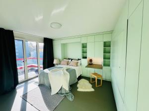 Un dormitorio con una cama y un escritorio y una ventana. en Modern Living, Luxe Studio Zurich, en Zúrich