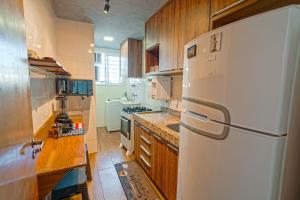 una cucina con frigorifero bianco e armadietti in legno di Conforto e estilo inspirado em Nova York - Centro de Palmas a Palmas