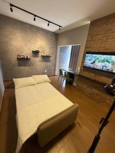 una camera da letto con un letto e una TV a schermo piatto di Conforto e estilo inspirado em Nova York - Centro de Palmas a Palmas