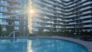 a swimming pool in front of a large apartment building at Mcity Morden 2BR with Free Parking in Clayton North