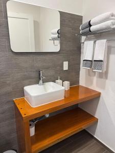 a bathroom with a sink and a mirror and towels at Casa en Huerto Frutal in Chicanna