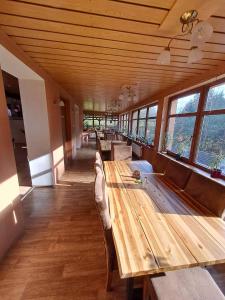 a room with a long wooden table with feet on it at Penzion Kongu in Telnice