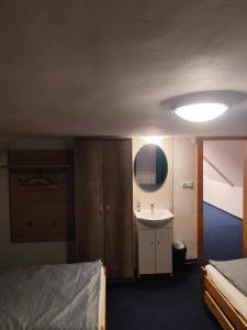 a bedroom with a bed and a sink and a mirror at Penzion Kongu in Telnice +7 photos