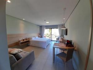 a bedroom with a bed and a couch and a table at Villas BobZ Barra grande in Barrinha