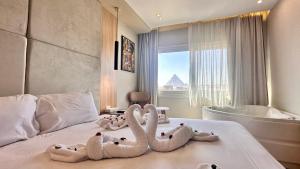 a hotel room with swans laying on a bed at Tiye Pyramids Hotel in Cairo