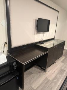 a desk with a monitor and a computer in a room at GO2 Inn & Suites by Relianse - El Paso in El Paso