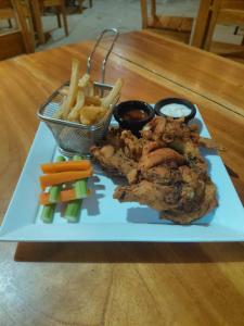 a plate of food with fried chicken and french fries at El Remanso Hotel y Restaurante in Rivas +21 photos