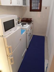 a small kitchen with a stove and a microwave at Diverso in Zelenika