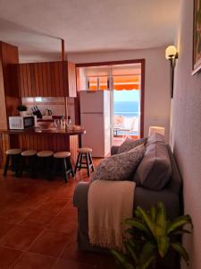 ein Wohnzimmer mit Couch und Küche in der Unterkunft Mi Pequeño Paraíso in El Pris