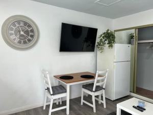 a kitchen with a table and two chairs and a clock at Ventura Blvd Guest House in Litton Industries Heliport