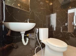 a bathroom with a white toilet and a sink at TJ Brother Residences Cengkareng in Jakarta