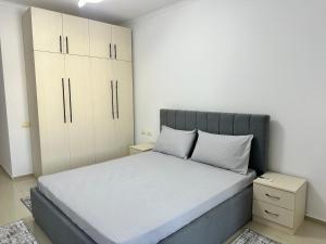 een slaapkamer met een groot bed en witte kasten bij Premium Apartments Tirana Cumani in Tirane
