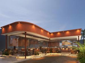 uma casa com um pátio exterior com mesas e cadeiras em Nexus House Signature Xuân Thuỷ em Cidade de Ho Chi Minh