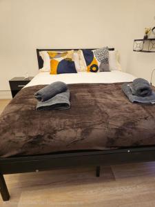 a bed with two pillows and towels on it at Story Haus apartments in Chester