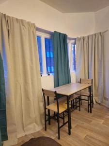 a table and chairs in a room with windows at Story Haus apartments in Chester
