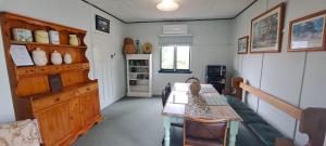 a room with a table and a bench in it at Heartland cottage in Ross